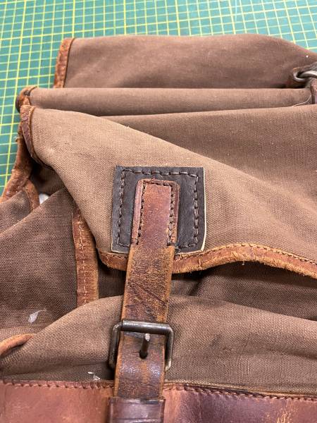 Couture main point sellier sur sac de chasse